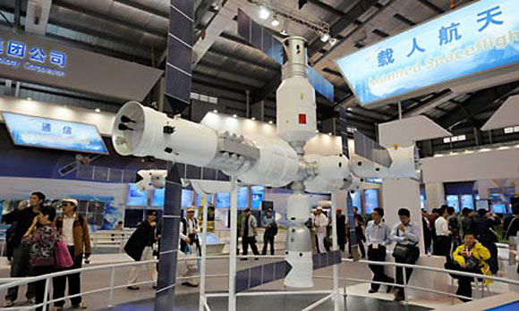 Visitors to the Airshow China exhibition look at a model of the Tiangong-1 space station