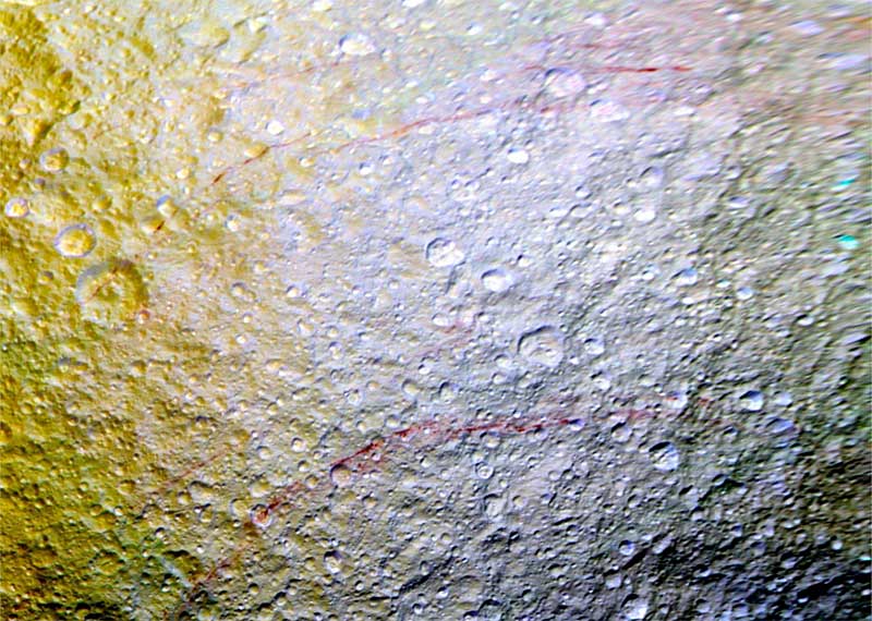 Unusual arc-shaped, reddish streaks cut across the surface of Saturn's ice-rich moon Tethys in this enhanced-color mosaic.