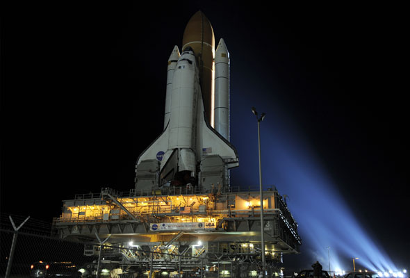 Bathed in bright xenon lights, space shuttle Discovery