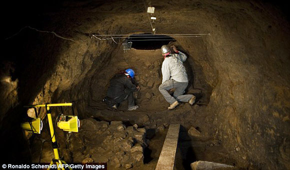 Archaeologists work inside a tunnel found under the ruins of the Feathered Serpent Temple